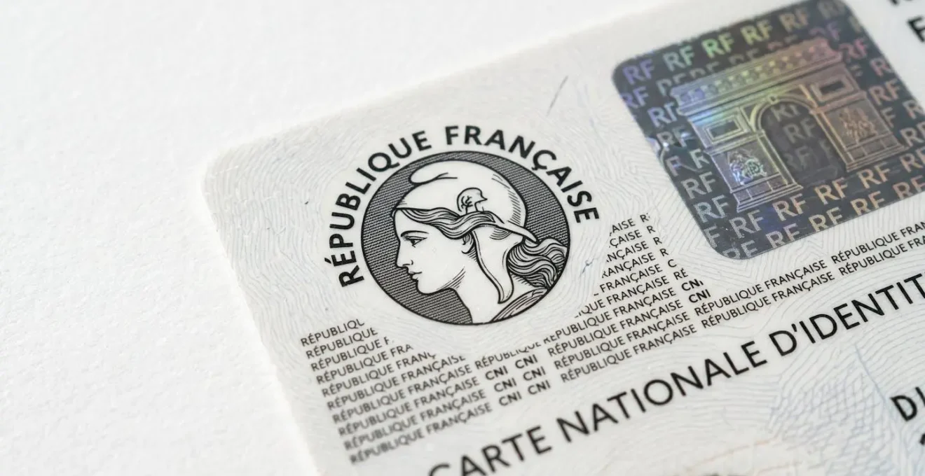 Gros plan sur une carte d'identité française posée sur une surface blanche avec focus sur les éléments de sécurité officiels